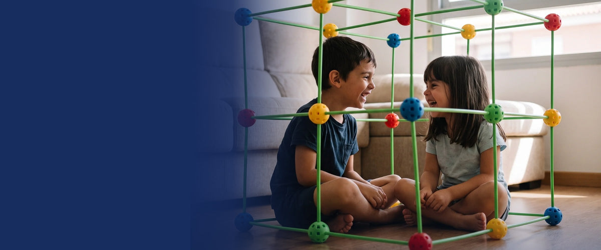 Dos hermanos riendo dentro de su cabaña de construcción en el salón
